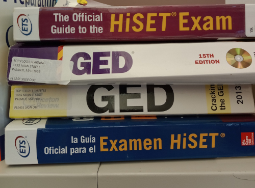 A small pile of HiSET and GED exam prep books.