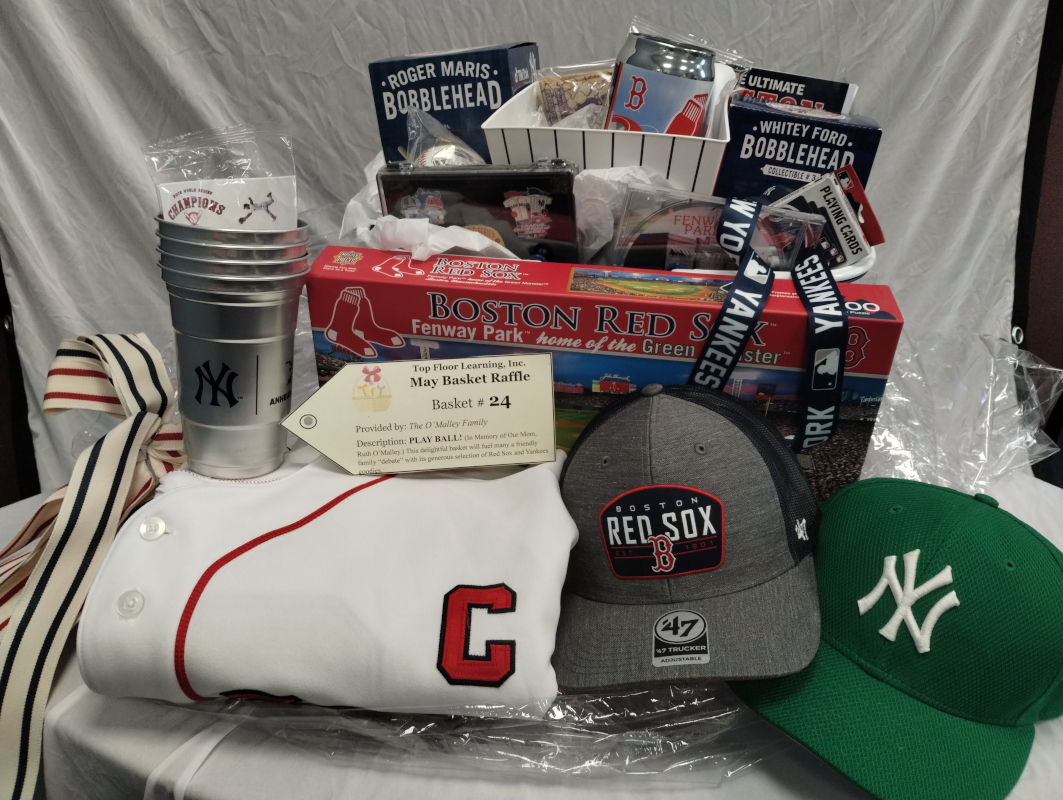 photo of an absolutely overstuffed basket of Yankees and Red Sox gear including hats, a jersey, puzzle, cups, bobblehead, and much much more