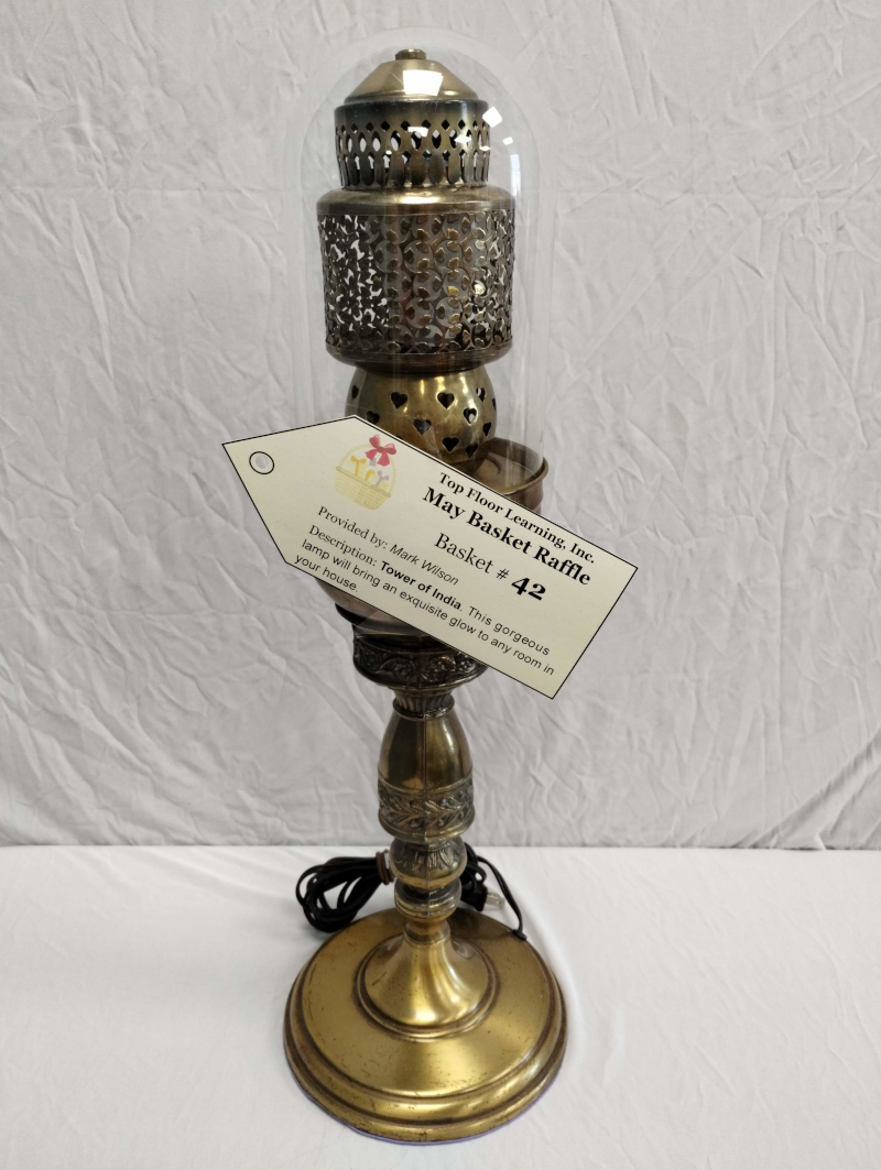 image of a taller brass-colored lamp with artful holes around where the bulb goes.